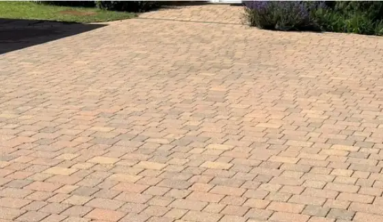 The same block paving restored to its original warm buff colour after cleaning